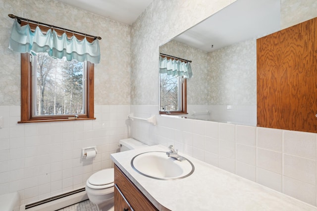 bathroom with baseboard heating, wainscoting, toilet, and wallpapered walls