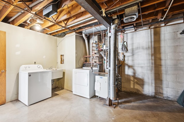 unfinished basement featuring visible vents, a sink, and washing machine and clothes dryer