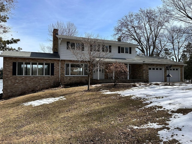 traditional-style home featuring brick siding, an attached garage, and a chimney