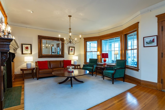 living area with a chandelier, ornamental molding, a fireplace, and wood finished floors