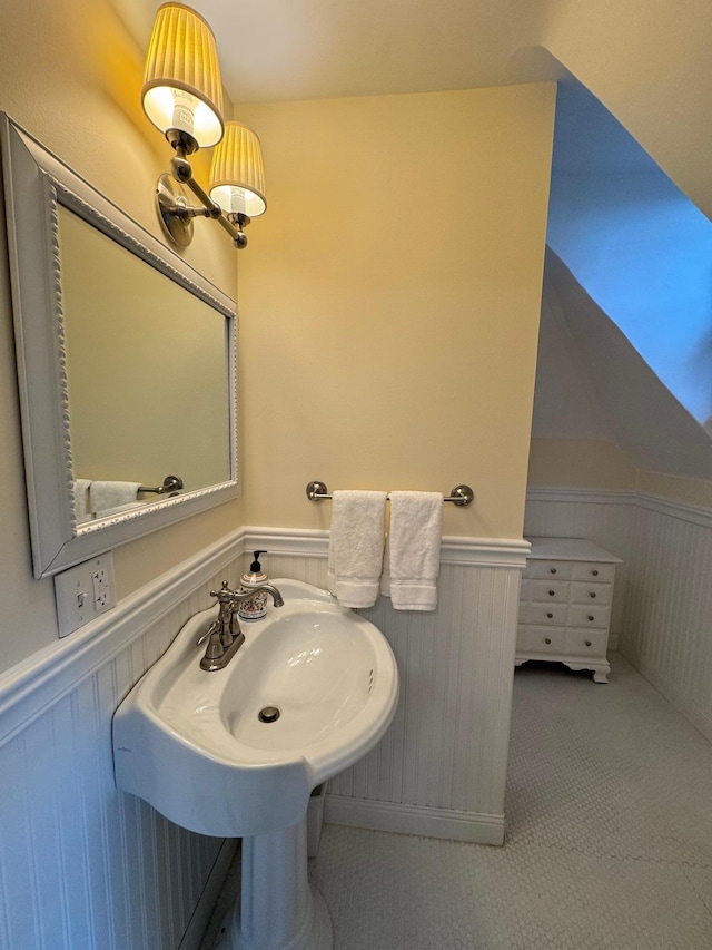 bathroom featuring lofted ceiling and wainscoting