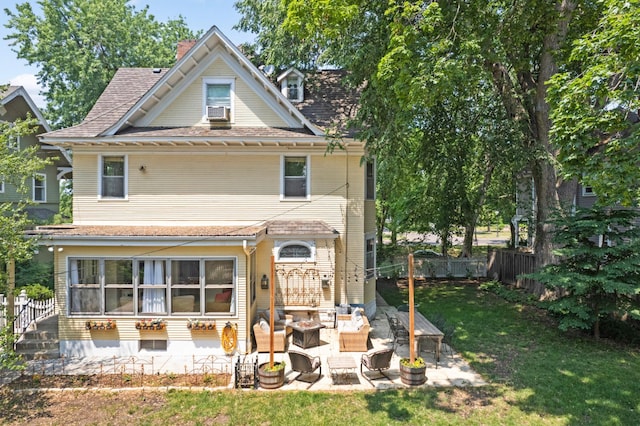 view of front of home featuring a fenced backyard, a chimney, a front lawn, and a patio