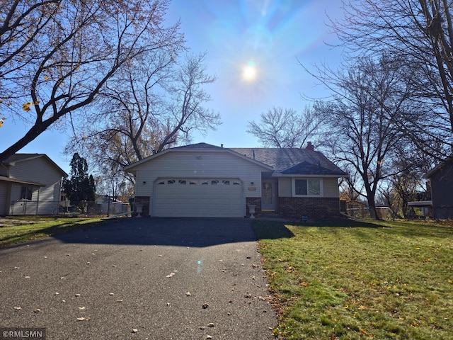 view of front facade with a garage, aphalt driveway, a front lawn, and brick siding