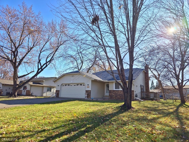 ranch-style house with a garage, brick siding, driveway, and a front lawn