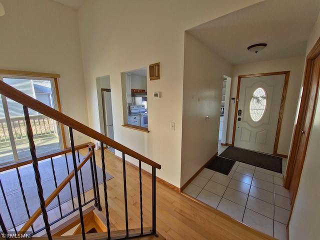 entryway featuring stairway, light wood-style flooring, and baseboards