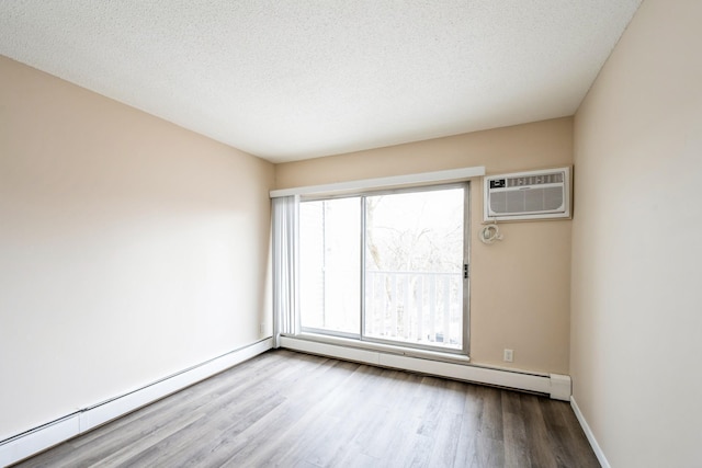 unfurnished room featuring a wall mounted AC, a baseboard radiator, wood finished floors, and baseboards