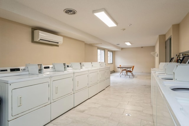shared laundry area featuring a wall mounted air conditioner, visible vents, and separate washer and dryer