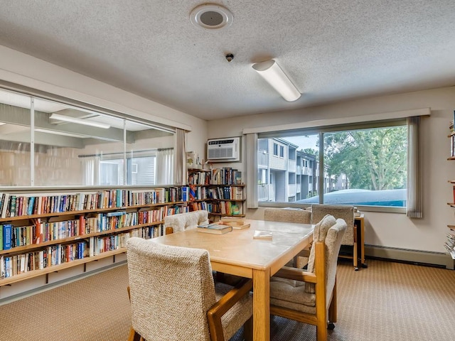 interior space with a baseboard heating unit, baseboards, a textured ceiling, and a wall unit AC