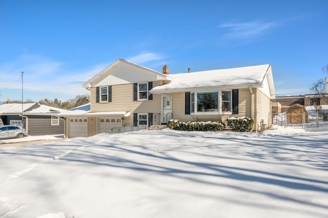 tri-level home featuring a chimney and an attached garage