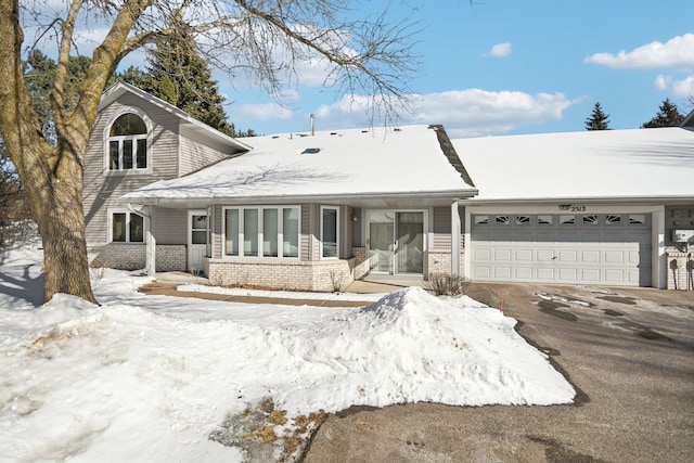 view of front of property with a garage, driveway, and brick siding