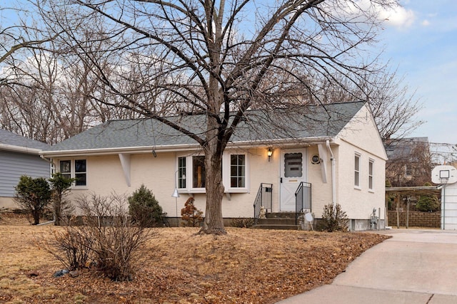 view of front of property with a carport, stucco siding, concrete driveway, and a shingled roof