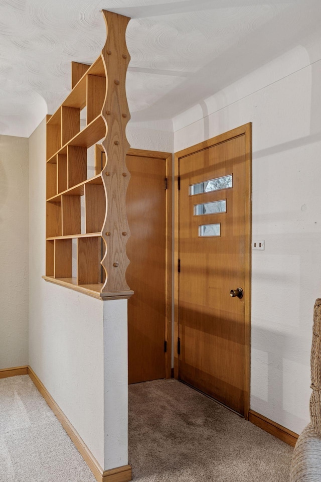 carpeted foyer with baseboards