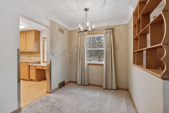 unfurnished dining area featuring visible vents, light colored carpet, and baseboards