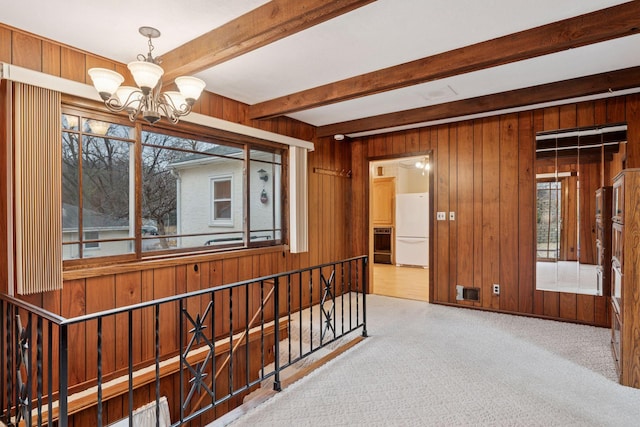 corridor with beam ceiling, wooden walls, carpet flooring, and a healthy amount of sunlight