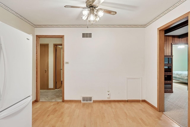 unfurnished room with visible vents, baseboards, a ceiling fan, and wood finished floors