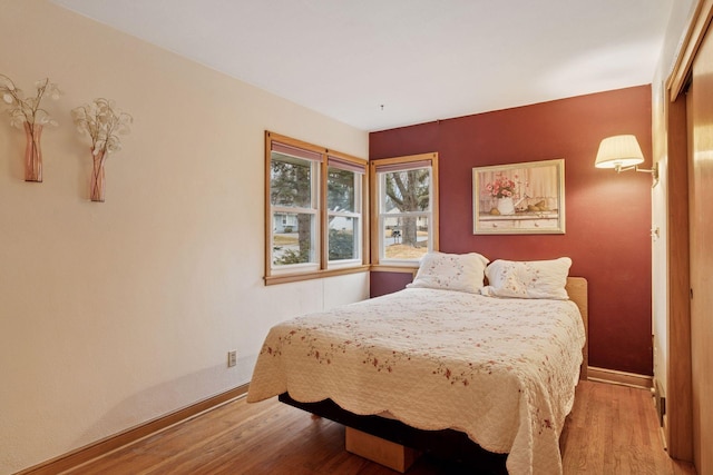 bedroom with baseboards and light wood-type flooring