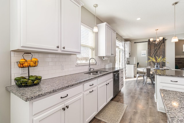 kitchen featuring backsplash, white cabinetry, a sink, and wood finished floors