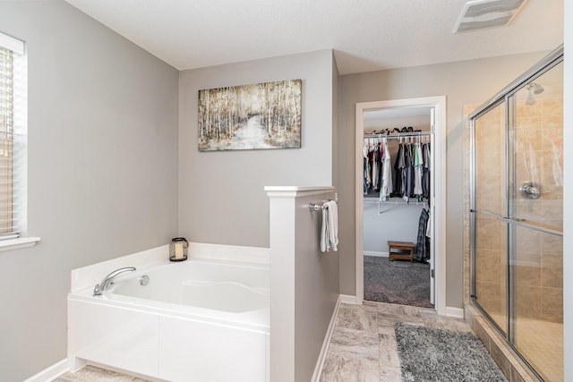 bathroom featuring visible vents, a garden tub, a stall shower, and a spacious closet