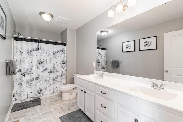 full bath with double vanity, toilet, and a sink