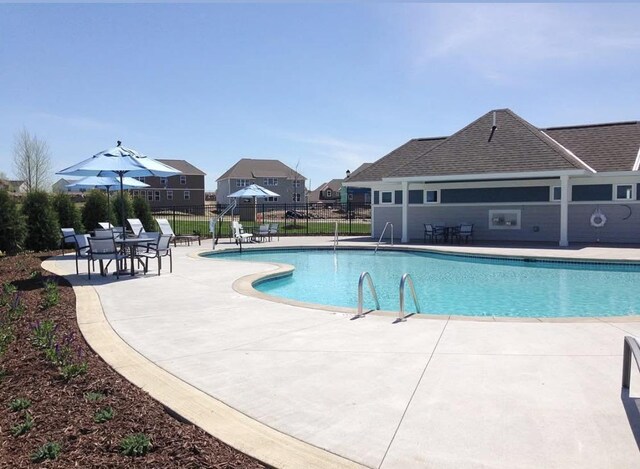 community pool featuring fence and a patio