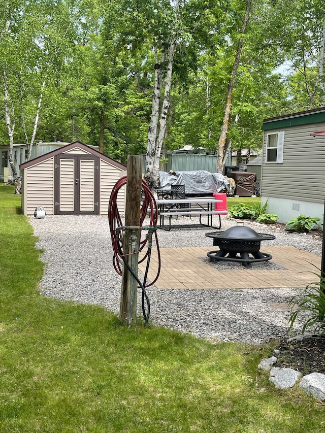 6631 Rocky Point Rd NW, Lakewood Twp, MN 56673 - view of grassy yard with a fire pit, a storage unit, and a deck