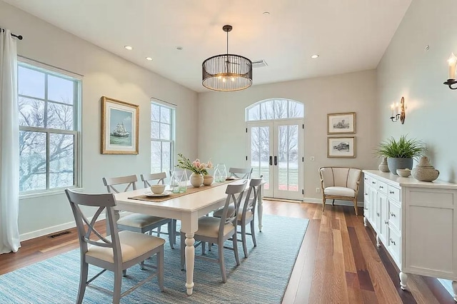 dining space featuring a wealth of natural light, baseboards, wood finished floors, and french doors