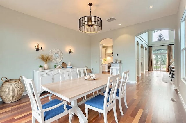 dining space featuring arched walkways, recessed lighting, visible vents, light wood-style flooring, and baseboards