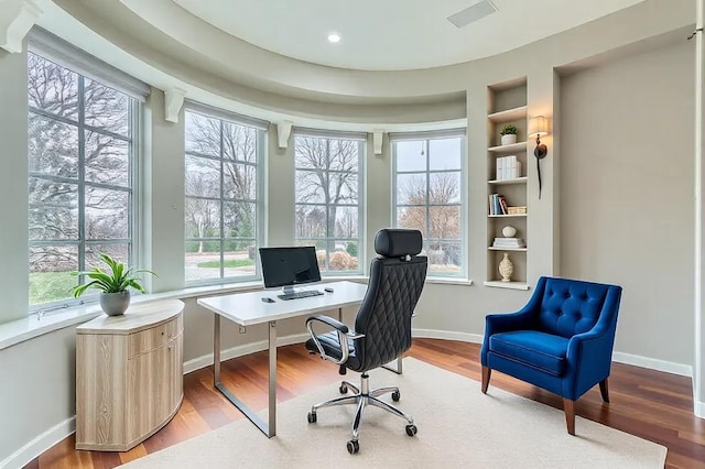 office space featuring baseboards, visible vents, built in features, wood finished floors, and recessed lighting