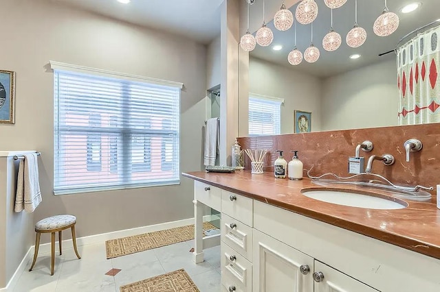 bathroom with tile patterned flooring, vanity, and baseboards