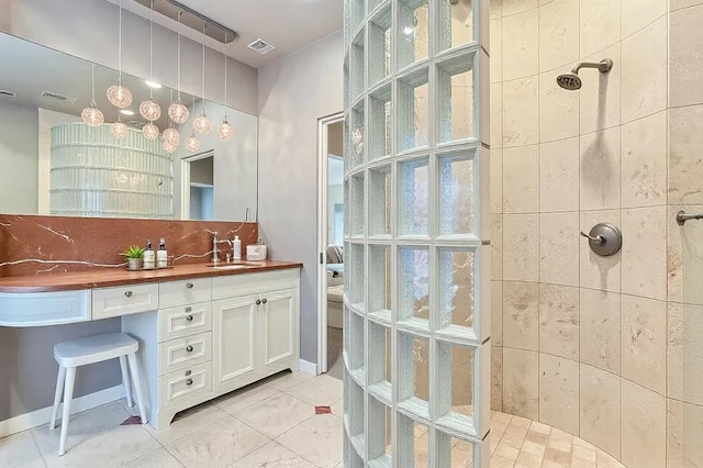 bathroom with a walk in shower, vanity, visible vents, backsplash, and tile patterned floors