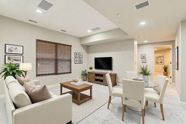 living room featuring light carpet, visible vents, and recessed lighting