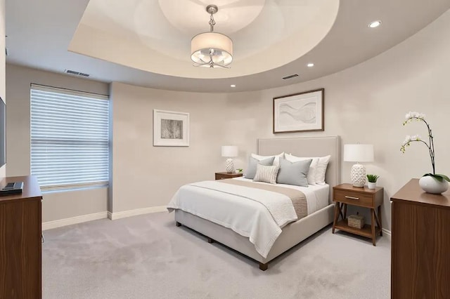 carpeted bedroom with baseboards, visible vents, and a raised ceiling