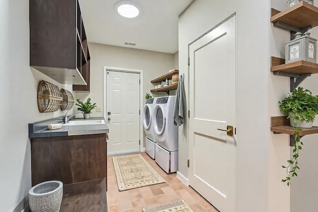 laundry area with washer and dryer, visible vents, and a sink