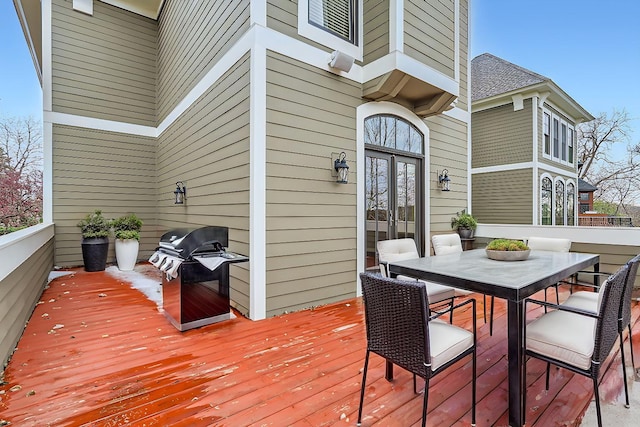 deck featuring outdoor dining area, french doors, and grilling area