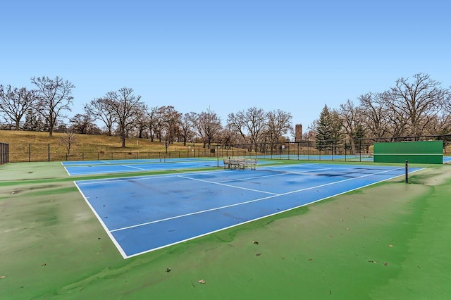 view of tennis court featuring fence