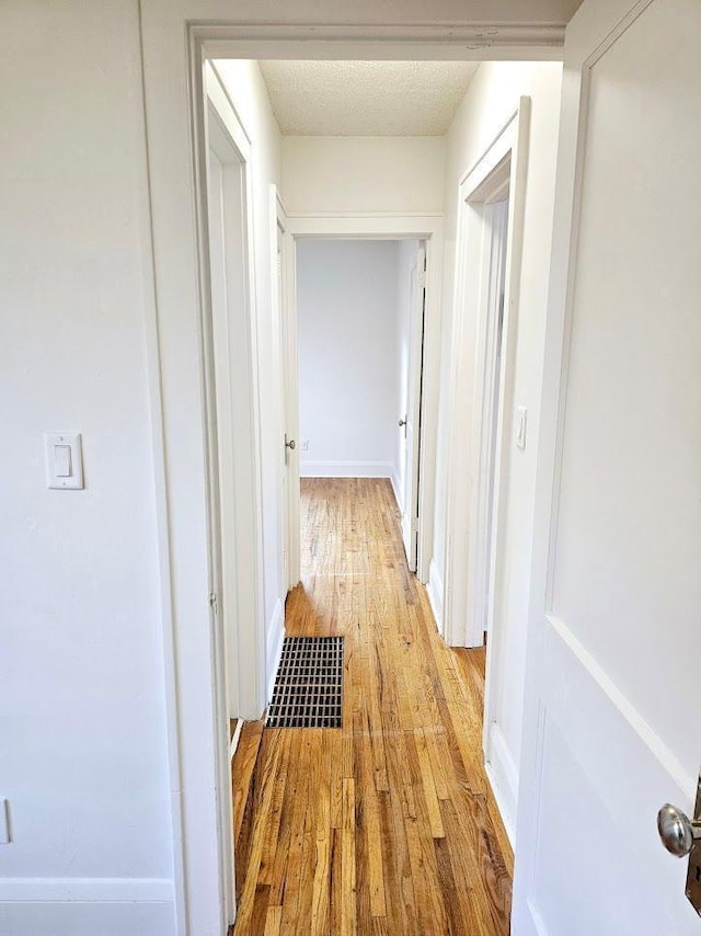 hall featuring visible vents and light wood finished floors