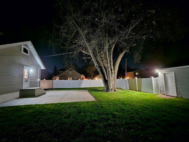 yard at twilight featuring a patio area and a fenced backyard