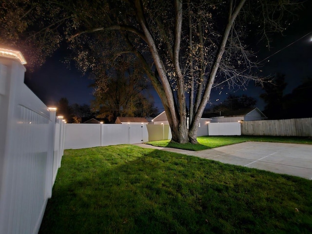 yard at twilight featuring a patio area and a fenced backyard