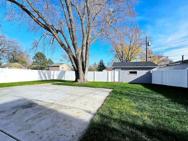 view of yard featuring a patio, an outdoor structure, and a fenced backyard