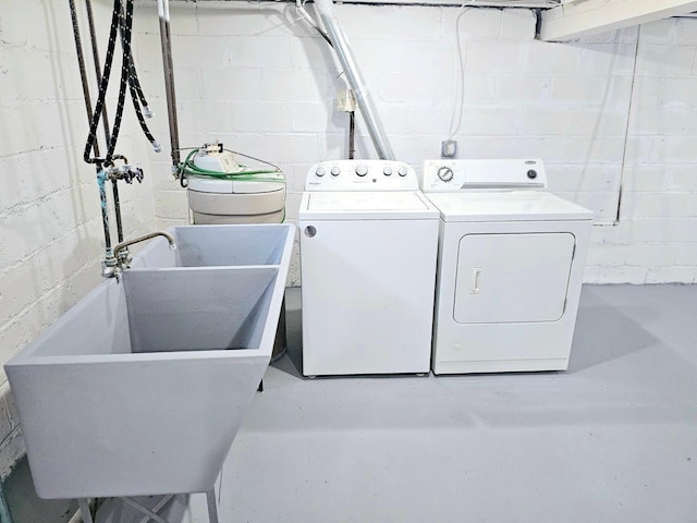 clothes washing area with a sink and washing machine and clothes dryer