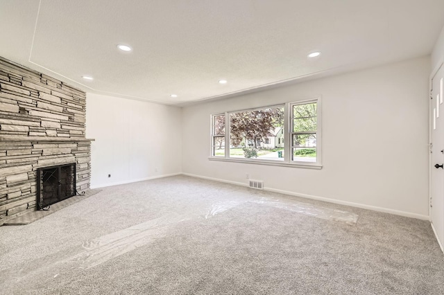 unfurnished living room with carpet flooring, a fireplace, recessed lighting, and baseboards