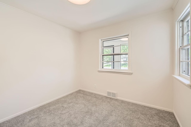 carpeted empty room featuring baseboards and ornamental molding