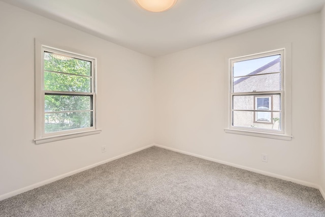 unfurnished room with carpet floors and baseboards