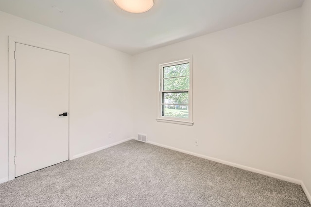 carpeted empty room with baseboards