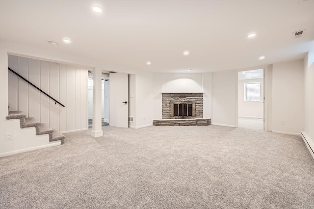 unfurnished living room featuring recessed lighting, carpet flooring, a fireplace, baseboards, and stairway