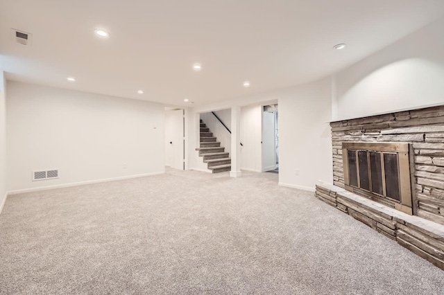 unfurnished living room with stairway, carpet flooring, recessed lighting, a fireplace, and baseboards