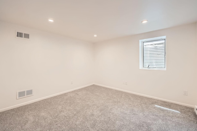carpeted empty room featuring baseboards and recessed lighting