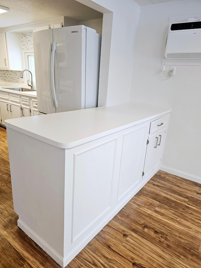 kitchen featuring white cabinets, light countertops, a sink, and freestanding refrigerator