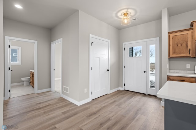 entryway featuring light wood finished floors, visible vents, and baseboards