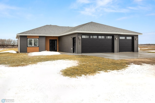 view of front of house featuring a garage and roof with shingles